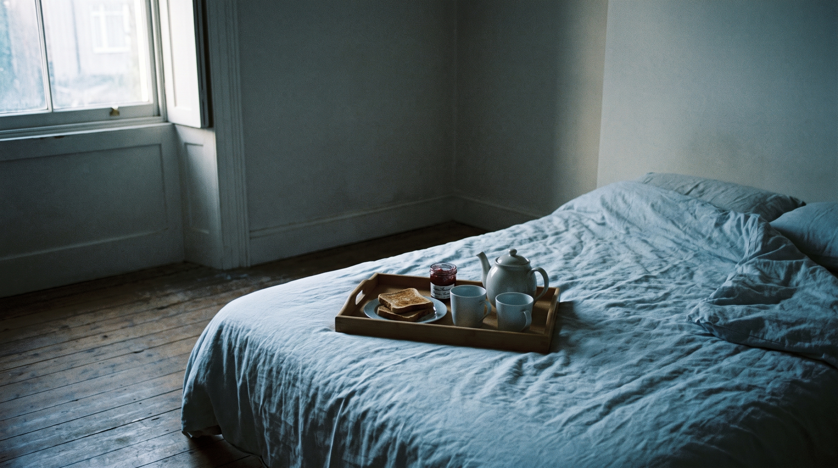 Pale morning bedroom scene with untouched breakfast tray